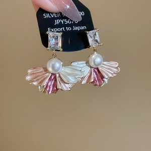 Detailed close-up of fan-shaped pearl earrings with zircon inlay and enamel petals