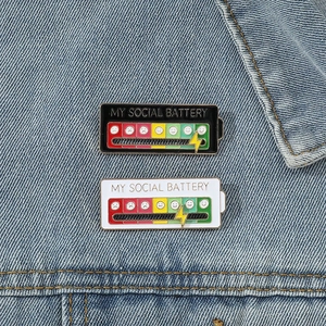 Interactive My Social Battery enamel pin set on denim background with slider feature