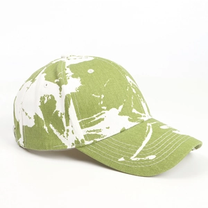 Détail d'une casquette en coton avec éclaboussures de peinture verte et visière