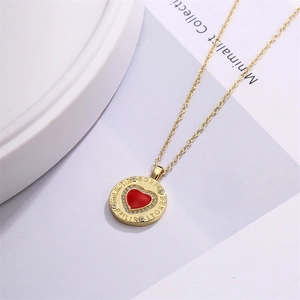 Golden round pendant necklace with red heart and zircon stones on a fine cross chain