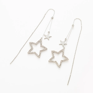 Detail of silver long drop earrings featuring crystal star pendants and polished chain