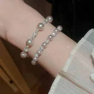Bracelet élégant en perles de rose et zircons scintillants au poignet d'une femme