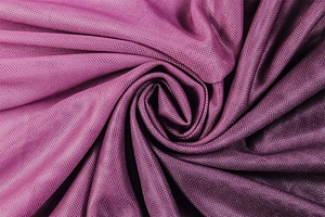 Vista macro della texture in tessuto a rete viola con elegante drappeggio a spirale
