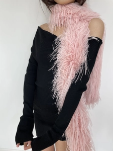 Close-up of pink faux mink fur scarf texture paired with a black knit off-shoulder dress