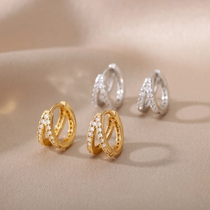 Double-layered interlocking C-shape huggie earrings with cubic zirconia in gold and silver