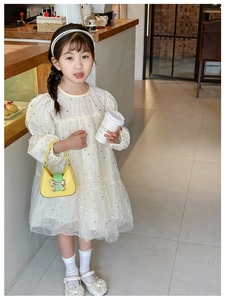 Detail view of girl's cream puff sleeve mesh dress with golden star patterns