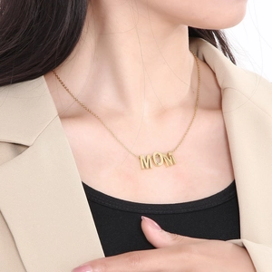 Gros plan d'un collier doré avec pendentif MOM porté par un mannequin pour cadeau