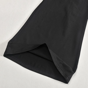 Détail de la combinaison noire montrant l'ourlet à double couture et la texture du tissu