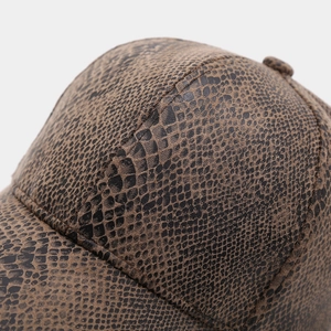 Detailed view of brown snakeskin texture and reinforced stitching on the baseball cap