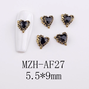 Macro shot of 5.5x9mm heart-shaped gothic nail charms with vintage gold wing frames