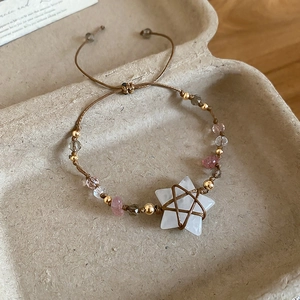 Detail of bohemian woven bracelet featuring white star crystal and pink natural stone beads