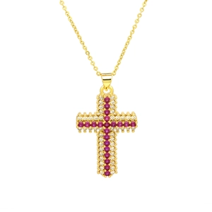 Detailed close-up of a golden cross pendant with inlaid pink and white cubic zirconia