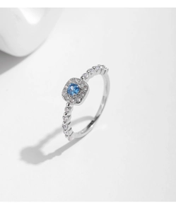 Detail of s925 silver ring featuring a halo-set square blue opal and radiant accents
