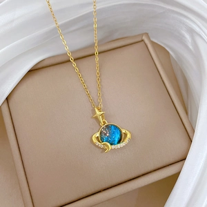 Detailed shot of celestial planet necklace with blue gem and crystals on silk fabric