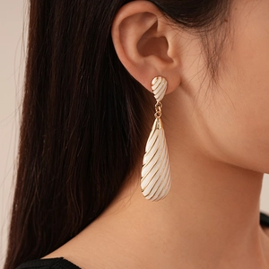 Detailed close-up of retro zebra stripe teardrop earring worn by a model in natural light