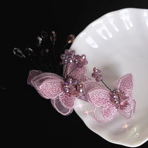Barrettes à cheveux papillons brodées violettes avec perles en cristal sur assiette blanche
