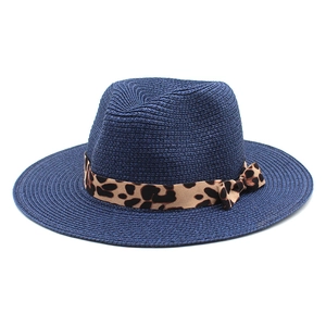 Detail of navy blue straw panama hat with leopard print ribbon and classic bow