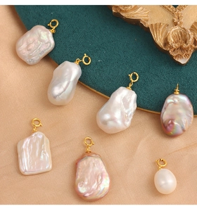 Macro view of baroque pearls with golden clasps on champagne and green background