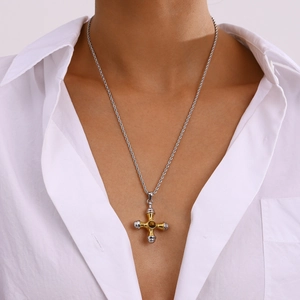 Détail du collier croix en acier bicolore avec pierre précieuse sur chaîne torsadée