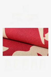 Detail showing high-quality fiber texture and durable stitched edges of the red door mat