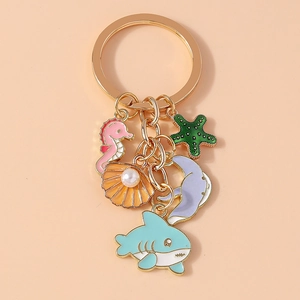 Detailed view of gold keychain with colorful enamel sea creature charms and pearls