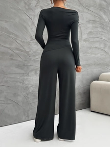 Back view of a black two-piece set featuring a long-sleeve top and wide-leg trousers