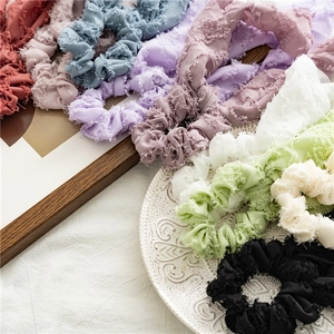 Detail of multi-colored textured knot hair scrunchies displayed on a vintage plate
