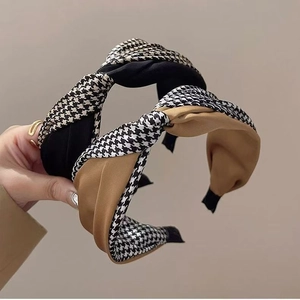 Detail of twisted wide headbands featuring black and khaki houndstooth fabric texture