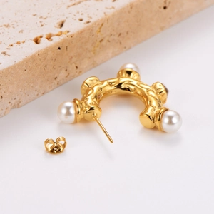 Golden vintage style pearl earrings featuring four symmetrical white pearls on white background
