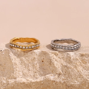 Chic 18K gold plated stainless steel wavy rings with crystals shown on light stone