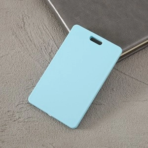 Top view of a durable blue plastic ID card holder on a grey textured background surface