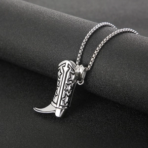 Detail of silver cowboy boot pendant with star motif on a display stand