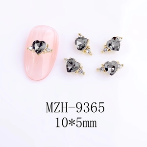 Macro detail of 10x5mm heart-shaped nail crystal with grey facets and gold base