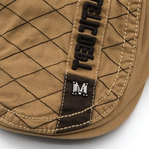 Close-up of khaki cotton beret with diamond stitching and silver M metal logo