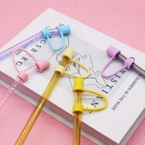 Colorful 10mm silicone straw covers and glass straws set on a pink background