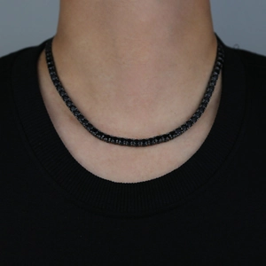 Detailed view of 5mm black tennis chain with dark purple zircon on a model