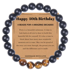 Bracelet 40 ans en œil de tigre et pierre noire mate sur carte cadeau kraft