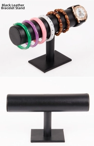 Three-tier black leather display stand showing bracelets and watches on a white background