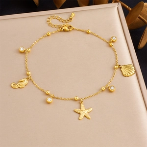 Gold stainless steel ocean anklet featuring starfish, seahorse and scallop charms
