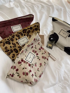 Detail view of corduroy leopard and floral print makeup bags with Pleasant Time label