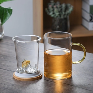 Glass tea cup with mountain infuser, wooden lid, and golden handle for office brewing