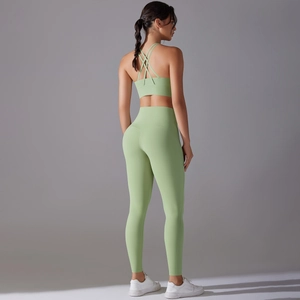 Detail of cross-back yoga bra and high-waisted leggings in light grass green