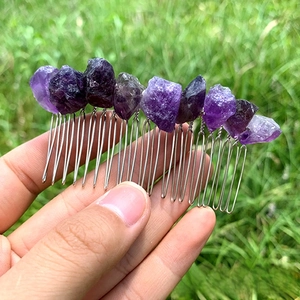 Detailed shot of handmade natural purple amethyst raw crystals on a silver hair comb