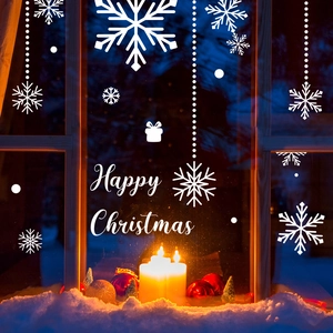 Close-up of Happy Christmas lettering and white snowflake static window stickers
