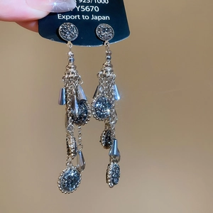 Macro shot of 925 silver needle earrings with dark rhinestone water drop tassels