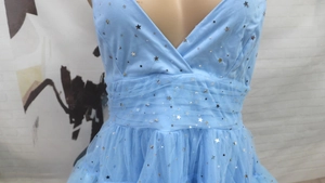 Detail of light blue mesh wedding dress with silver star and moon sequin embroidery