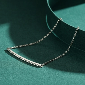 S925 sterling silver minimalist tennis bracelet with tiny diamonds on green background