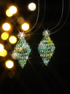 Macro detail of diamond rhombus earrings featuring green and yellow gradient crystals