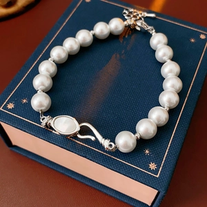 Close-up of elegant pearl bracelet with zircon shell clasp on a luxury gift box
