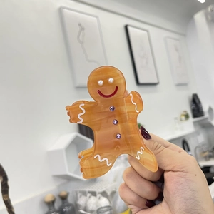Cute gingerbread man hair claw clip made of orange acetate with pearl and rhinestone details